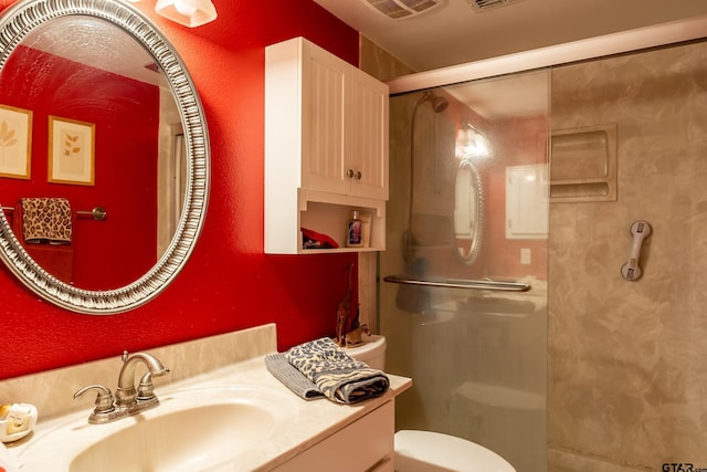 bathroom featuring vanity, toilet, and a shower with door