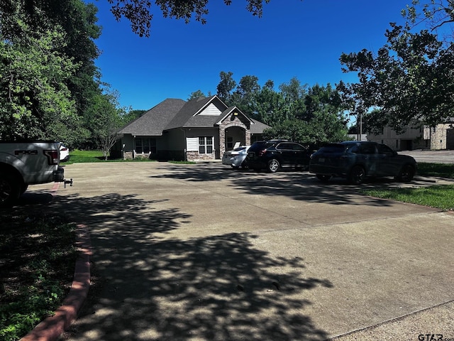 view of front of property with stone siding and concrete driveway