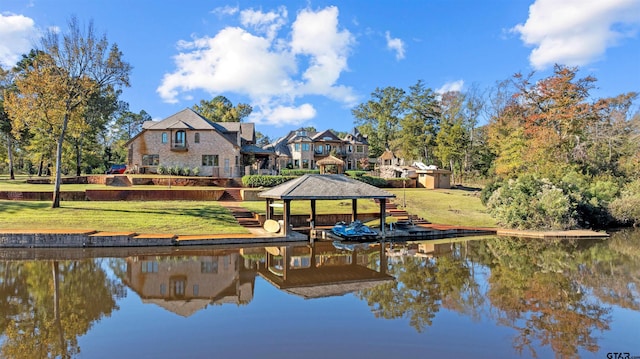 view of dock with a gazebo, a yard, and a water view