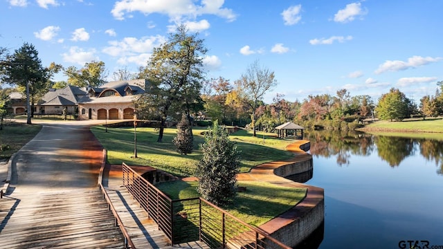 surrounding community featuring a water view, a gazebo, and a lawn