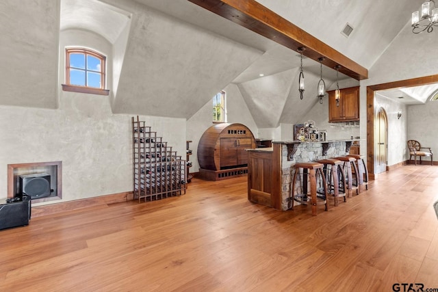 living room with light wood-type flooring, beamed ceiling, and a chandelier