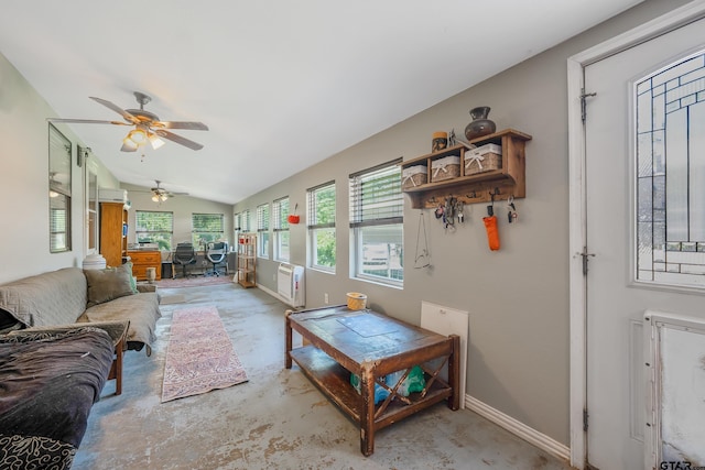 living area featuring concrete flooring, lofted ceiling, baseboards, and ceiling fan
