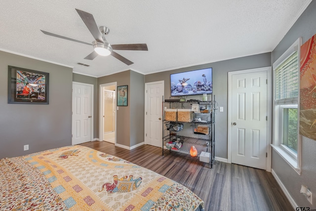 bedroom featuring visible vents, a textured ceiling, baseboards, and wood finished floors