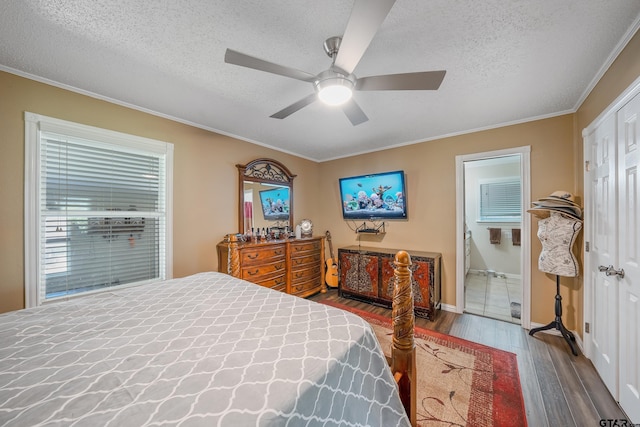 bedroom with a textured ceiling, wood finished floors, and ornamental molding