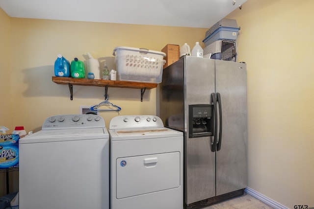 laundry room featuring laundry area, washing machine and clothes dryer, and baseboards