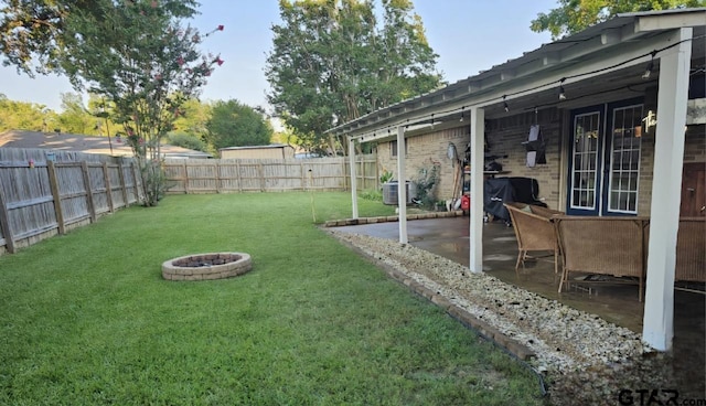 view of yard featuring a patio area, central air condition unit, a fire pit, and a fenced backyard