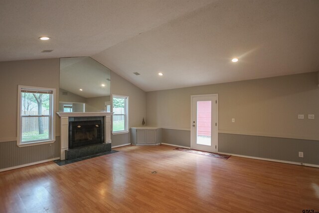 21298 Dogwood Dr, Flint, TX 75762 - unfurnished living room featuring a wainscoted wall, light wood-style flooring, vaulted ceiling, a fireplace, and recessed lighting