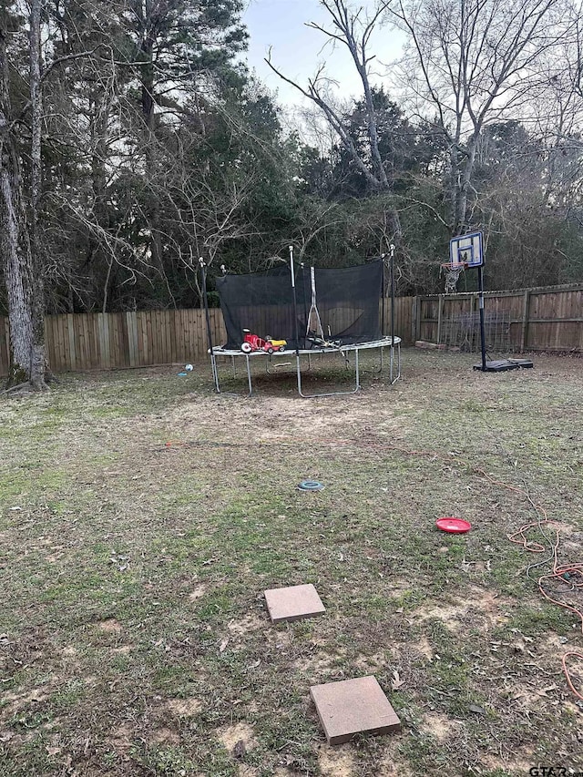 view of yard featuring a fenced backyard and a trampoline