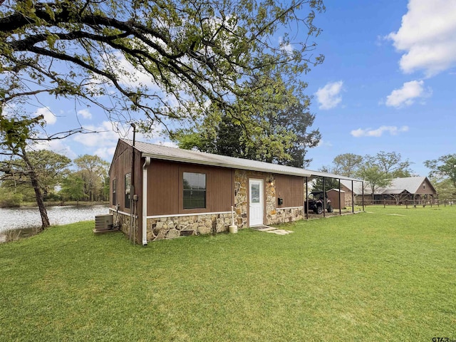 15250 Fm 858, Athens, TX 75752 - back of property with stone siding, cooling unit, a yard, and a water view