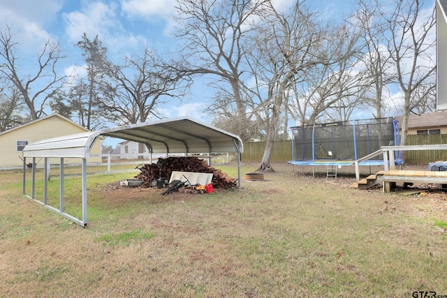 view of yard featuring a carport and a trampoline