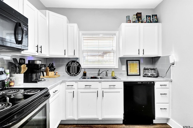 kitchen with sink, tasteful backsplash, white cabinetry, and black appliances