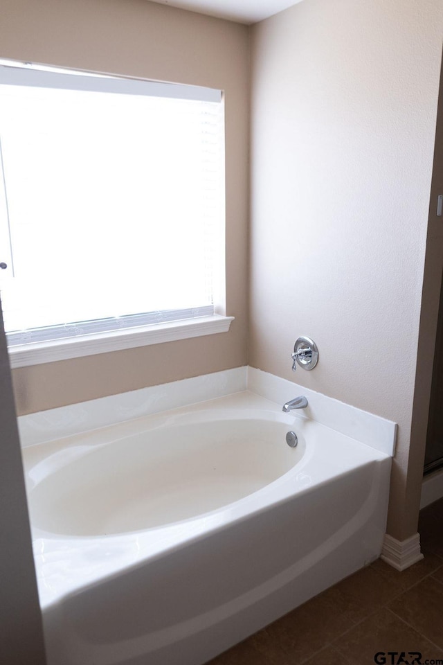 bathroom featuring a garden tub and tile patterned flooring