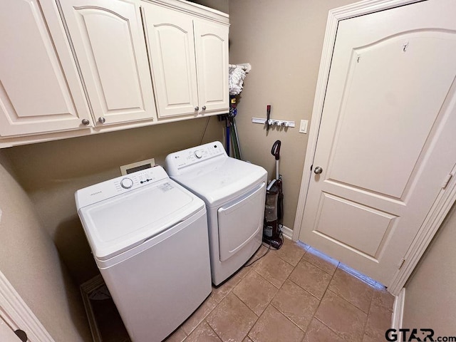 washroom with cabinet space, independent washer and dryer, and baseboards