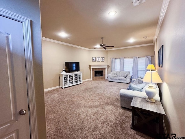 living area featuring carpet, visible vents, ornamental molding, a ceiling fan, and a tile fireplace