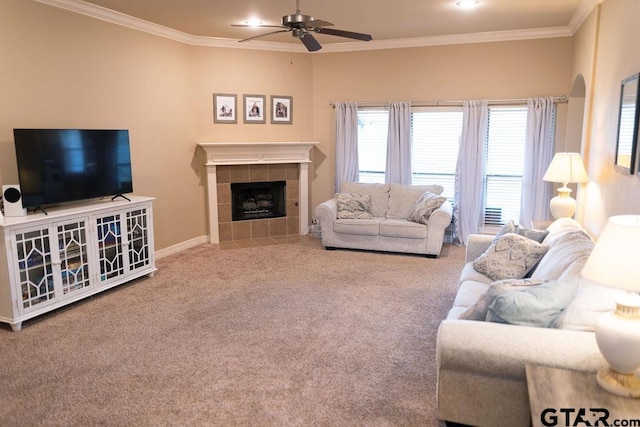 carpeted living area featuring a ceiling fan, baseboards, ornamental molding, and a tiled fireplace