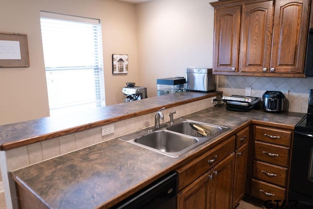 kitchen featuring dark countertops, decorative backsplash, a sink, a peninsula, and black appliances