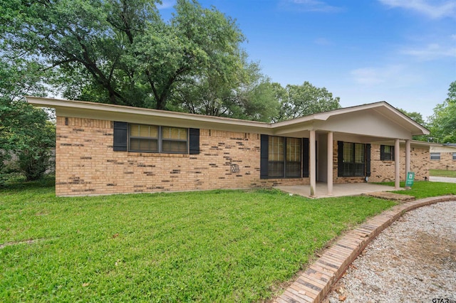8116 Jewell Ln, Tyler, TX 75703 - back of house with brick siding, a patio area, and a lawn