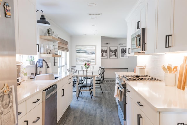 8116 Jewell Ln, Tyler, TX 75703 - kitchen featuring appliances with stainless steel finishes, a sink, open shelves, backsplash, and dark wood-style floors
