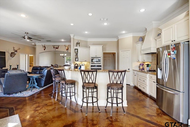 1009 Stagecoach Bnd, Bullard, TX 75757 - kitchen featuring appliances with stainless steel finishes, concrete flooring, a kitchen breakfast bar, premium range hood, and ceiling fan