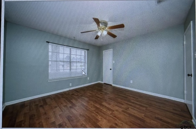 3729 Linda Kaye Dr, Longview, TX 75604 - empty room with a ceiling fan, dark wood-style floors, baseboards, and a textured ceiling