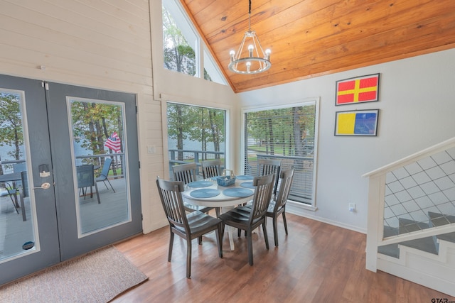 dining space with wooden ceiling, an inviting chandelier, high vaulted ceiling, hardwood / wood-style floors, and french doors