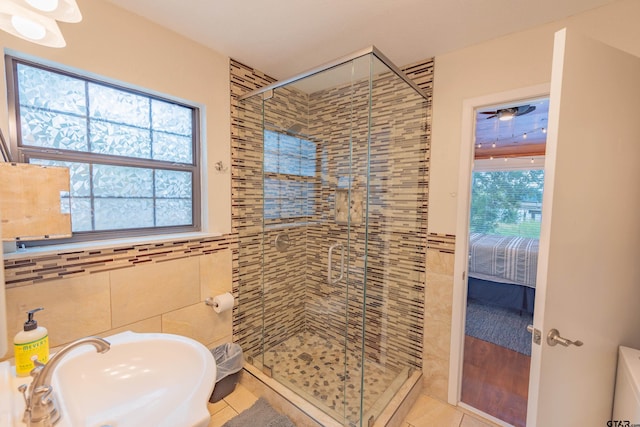 bathroom featuring walk in shower, tile patterned flooring, sink, and tile walls