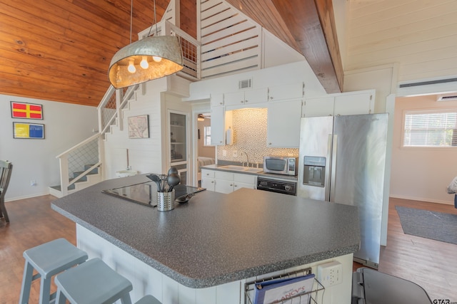 kitchen with dark wood-type flooring, white cabinetry, appliances with stainless steel finishes, and decorative backsplash