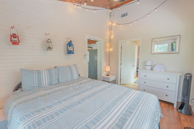 bedroom featuring light hardwood / wood-style floors and a high ceiling