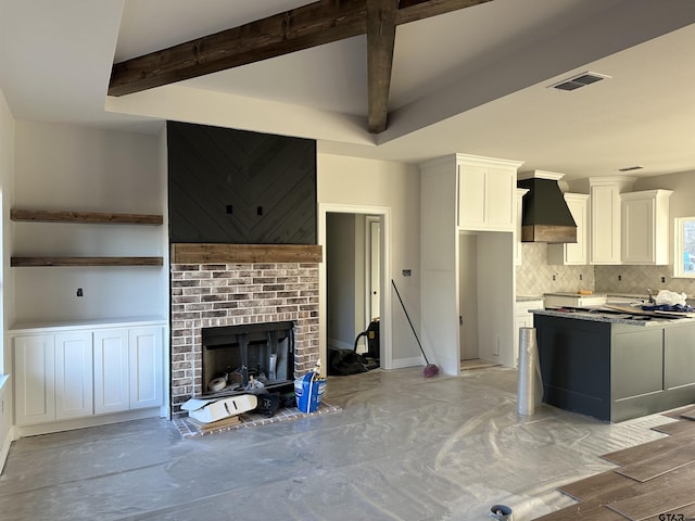 kitchen featuring premium range hood, a brick fireplace, tasteful backsplash, light hardwood / wood-style floors, and white cabinetry