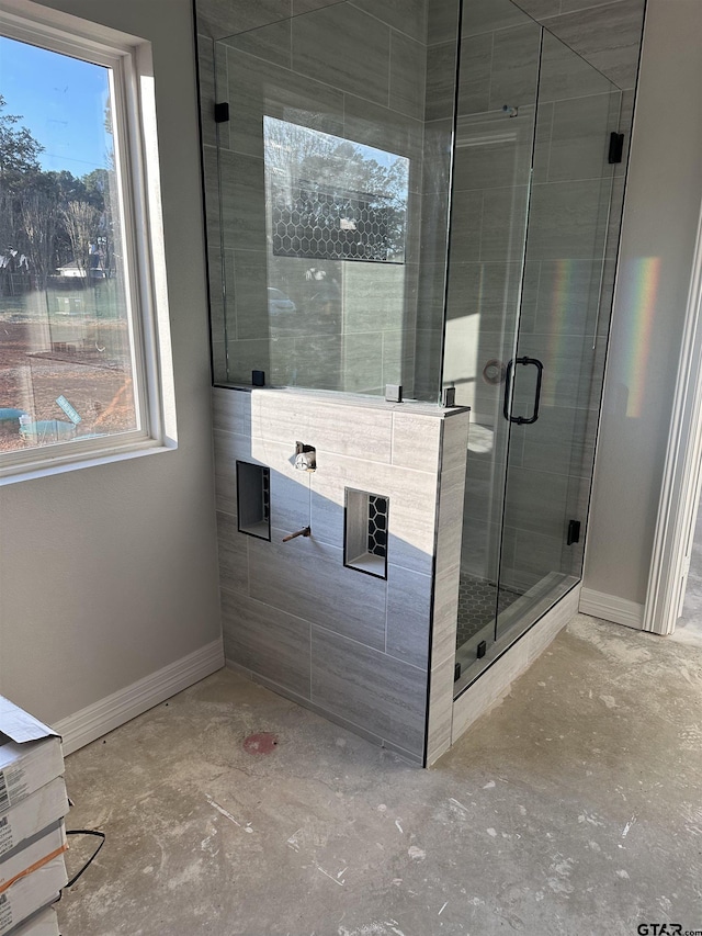 bathroom featuring a wealth of natural light and a shower with shower door