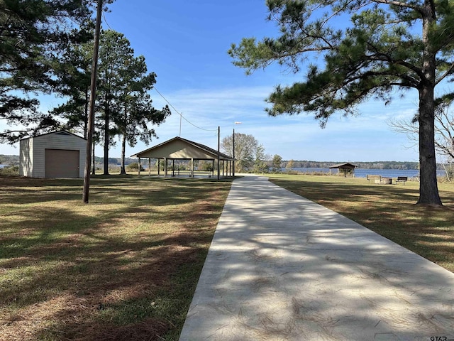 view of community featuring a gazebo, an outbuilding, a water view, and a lawn