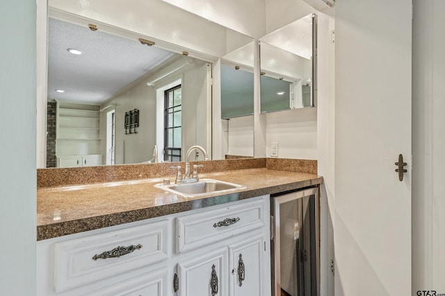 725 Purdue Dr, Tyler, TX 75701 - kitchen with beverage cooler, white cabinets, and dark countertops