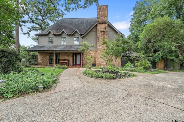 725 Purdue Dr, Tyler, TX 75701 - view of front of house featuring covered porch, a chimney, stucco siding, roof with shingles, and brick siding