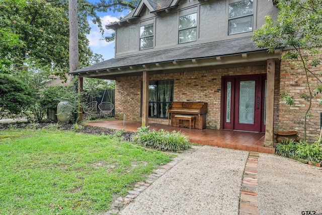 725 Purdue Dr, Tyler, TX 75701 - entrance to property featuring a lawn, brick siding, and stucco siding