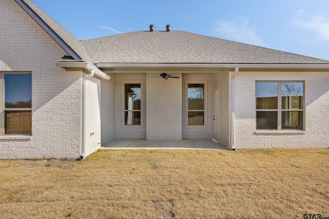 rear view of house with ceiling fan, a patio, and a yard