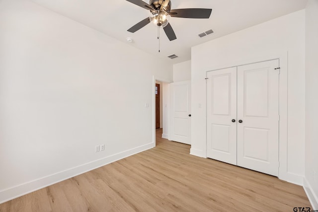 unfurnished bedroom featuring light hardwood / wood-style flooring, a closet, and ceiling fan