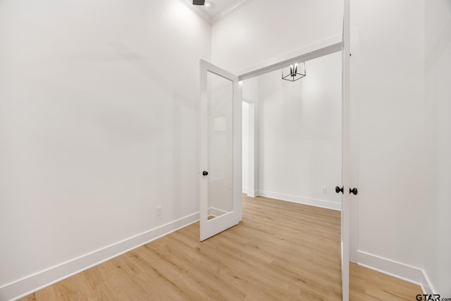 spare room with crown molding and light wood-type flooring