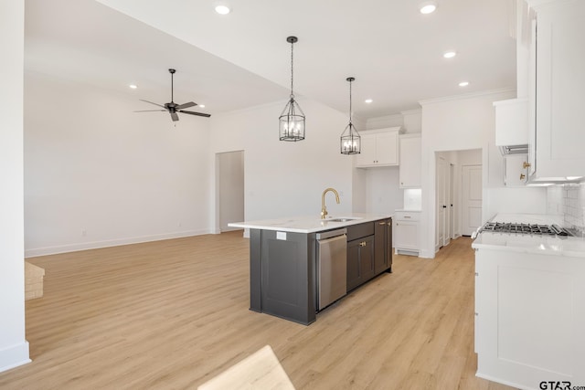 kitchen featuring stainless steel dishwasher, pendant lighting, light hardwood / wood-style flooring, white cabinets, and a kitchen island with sink