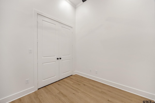 unfurnished room with ornamental molding and light wood-type flooring