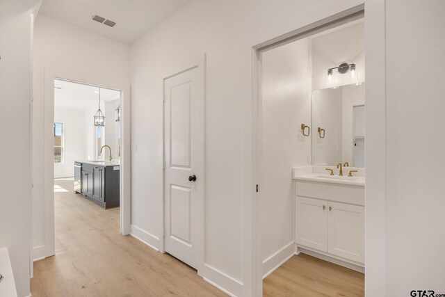 unfurnished dining area with a notable chandelier, ornamental molding, a healthy amount of sunlight, and light wood-type flooring