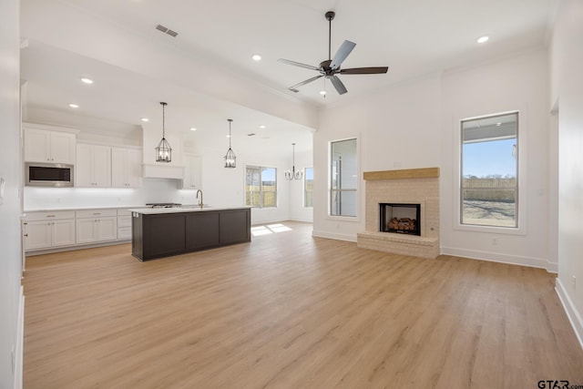 kitchen with an island with sink, white cabinetry, appliances with stainless steel finishes, and plenty of natural light