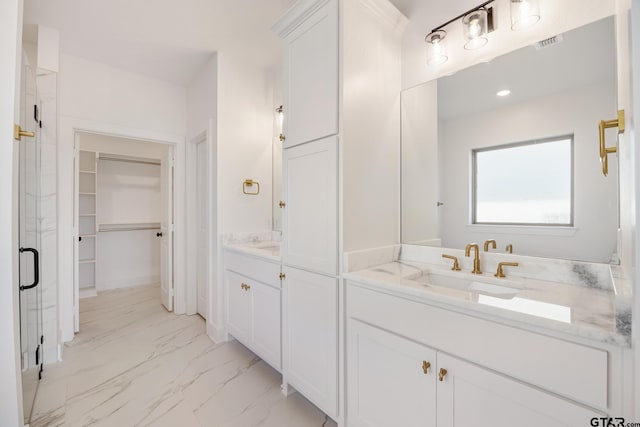 bathroom with a shower with shower door and vanity