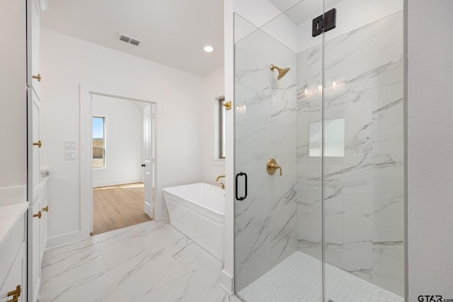 bathroom featuring shower with separate bathtub