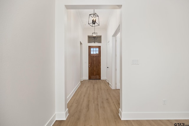 doorway to outside with crown molding and light hardwood / wood-style floors