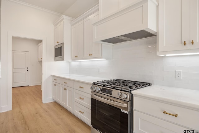 kitchen with appliances with stainless steel finishes, custom exhaust hood, white cabinets, light wood-type flooring, and light stone counters