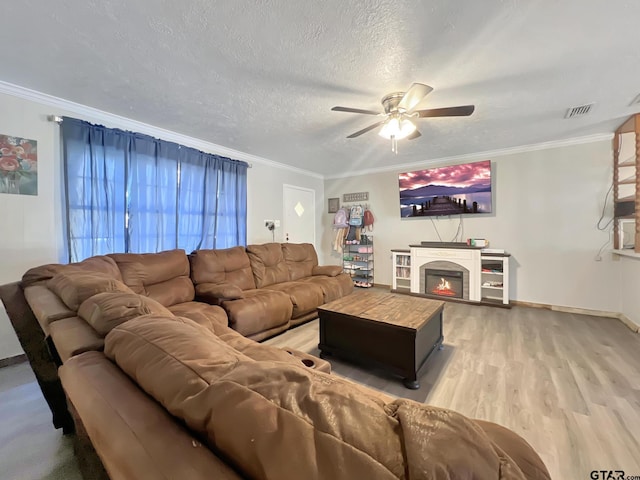 living room with hardwood / wood-style floors, crown molding, a textured ceiling, and ceiling fan