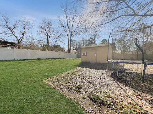 view of yard featuring an outbuilding and a trampoline