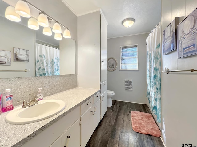 bathroom featuring hardwood / wood-style flooring, vanity, heating unit, ornamental molding, and toilet