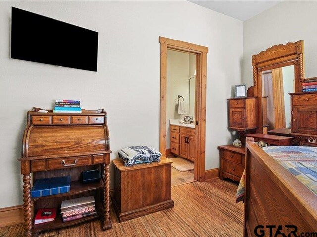 bedroom featuring light hardwood / wood-style flooring and connected bathroom