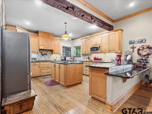 kitchen featuring stainless steel appliances, light hardwood / wood-style flooring, and a kitchen island